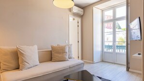 Una sala de estar moderna con un sofá, una mesa de centro y un televisor montado en la pared.