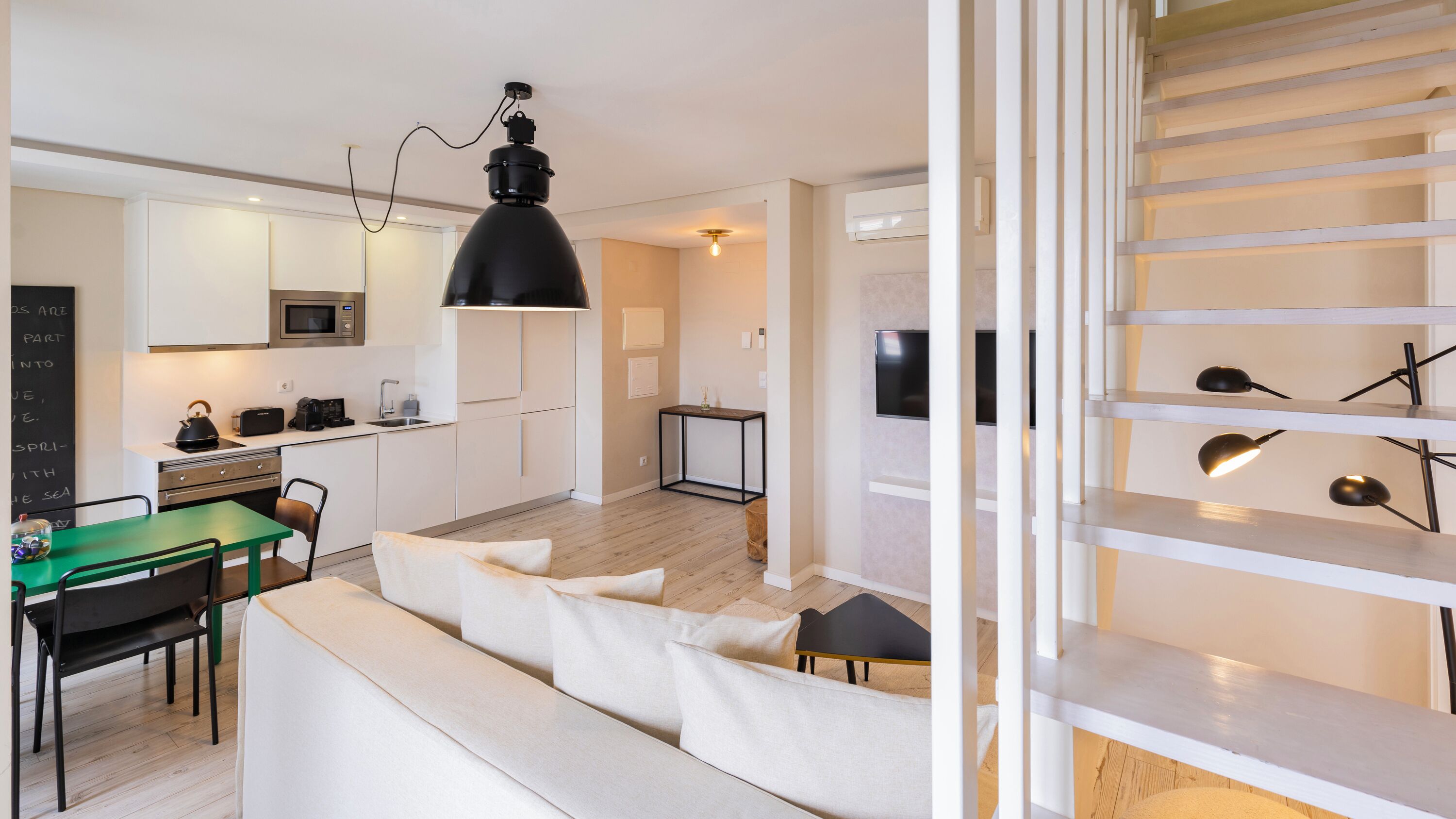 Un appartement moderne comprenant une cuisine, un coin repas et un salon.