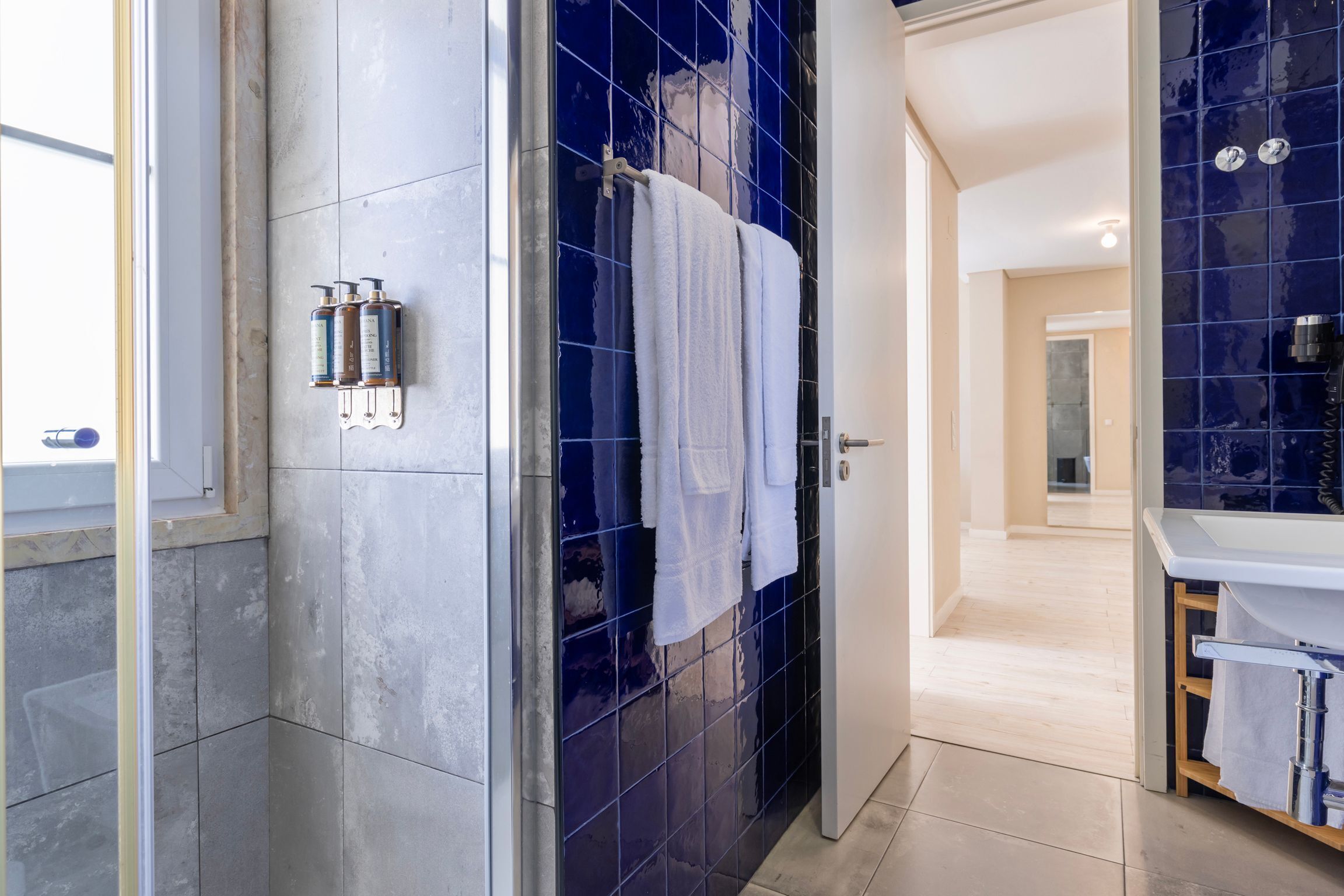 A modern bathroom with a shower, a sink, and a mirror.