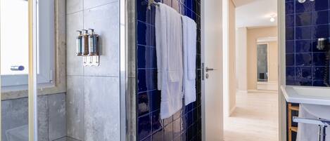 A modern bathroom with a shower, a sink, and a mirror.