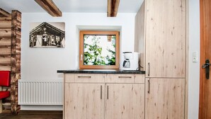 A modern kitchen with wooden cabinets, a built-in window, and a coffee maker.