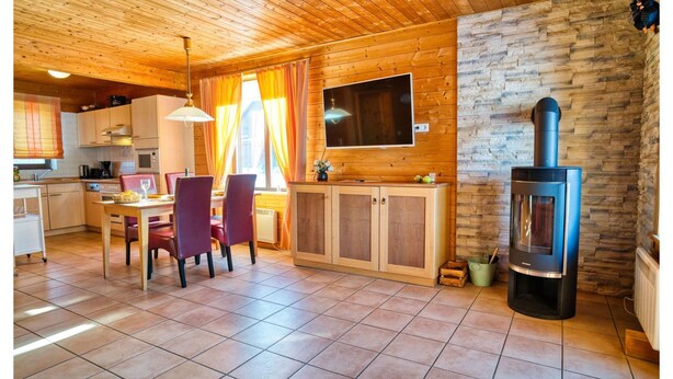 A wooden interior with a kitchen, dining area, and a fireplace. - Doppelhaushalfte in Hasselfelde (Oberharz am Brocken)