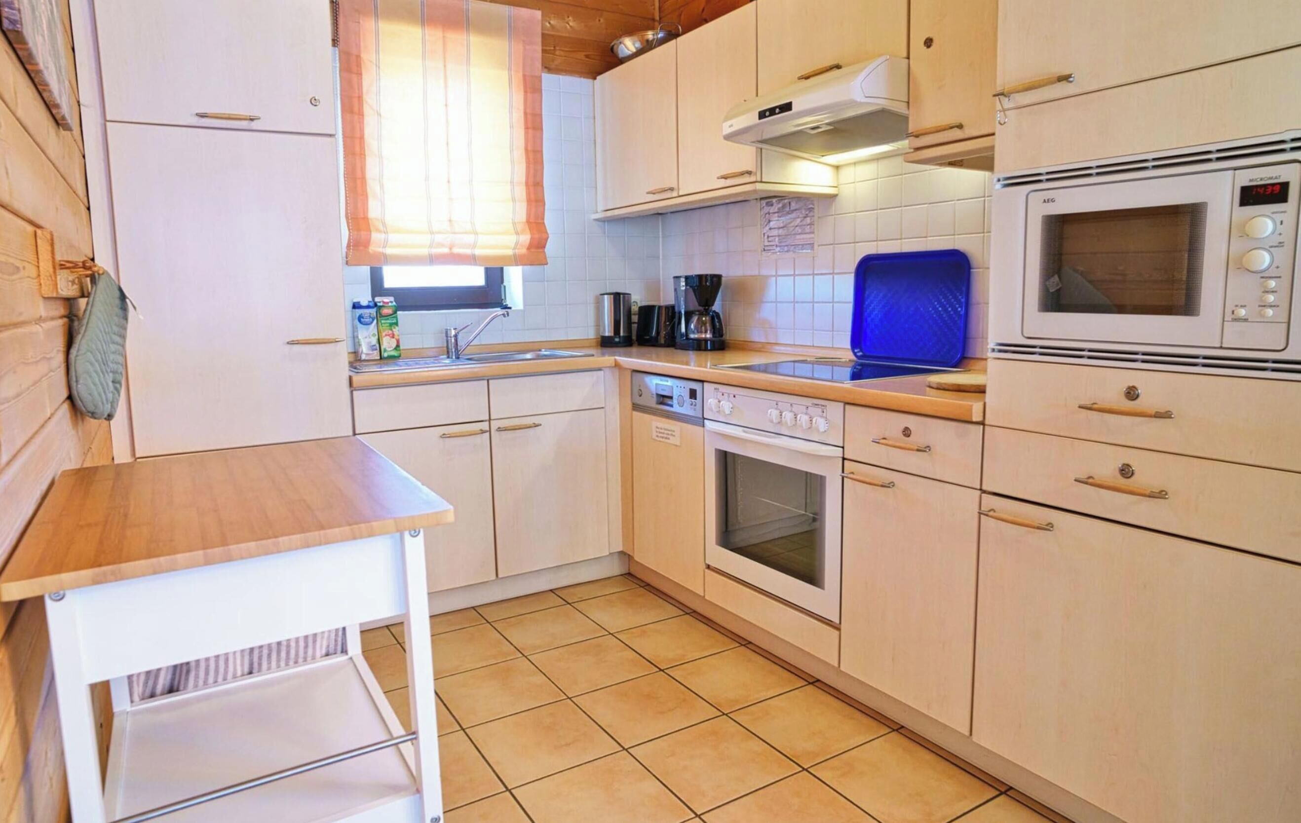 A compact kitchen with a refrigerator, oven, microwave, and a coffee maker.
