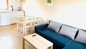 A compact living space with a kitchenette, a dining area, and a sofa. - Two-story Holiday Homes Close to the sea (Mielno)