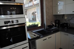 A modern kitchen with a built-in Whirlpool oven, a black stovetop, and a coffee maker. - Holiday Home Near Baltic Sea Swinoujscie (Swinoujscie)