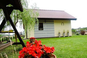 A single-story house with a tiled roof, a small porch, and a well-maintained lawn. - Holiday Home in Kolczewo Near Baltic Beaches (gmina Wolin)