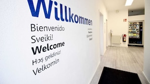A hallway with a welcome sign in multiple languages.