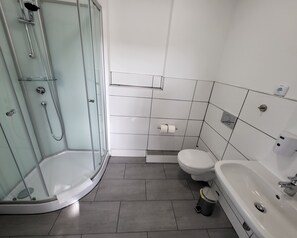 A modern bathroom with a glass-enclosed shower, a toilet, and a sink. - Zimmerwelt-Ilsfeld (Ilsfeld)