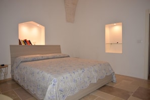 A bedroom with a bed, a bedside table, and two wall-mounted light fixtures. - Villa in Puglia Near Ostuni Marina (Ostuni)