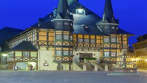 Een historisch gebouw met meerdere spitsen en een klokkentoren, kenmerkend voor een traditionele Europese architectuur.