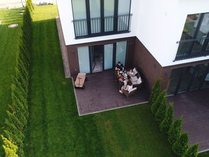 A modern two-story building with a covered patio area. - Ferienhaus in Damp Nahe Ostseestrand (Damp)