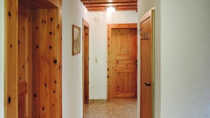 Un pasillo con puertas de madera y un cuadro en la pared.