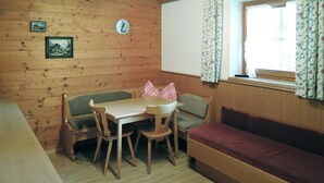 Un interior de madera con una mesa, sillas, un banco y un sofá.
