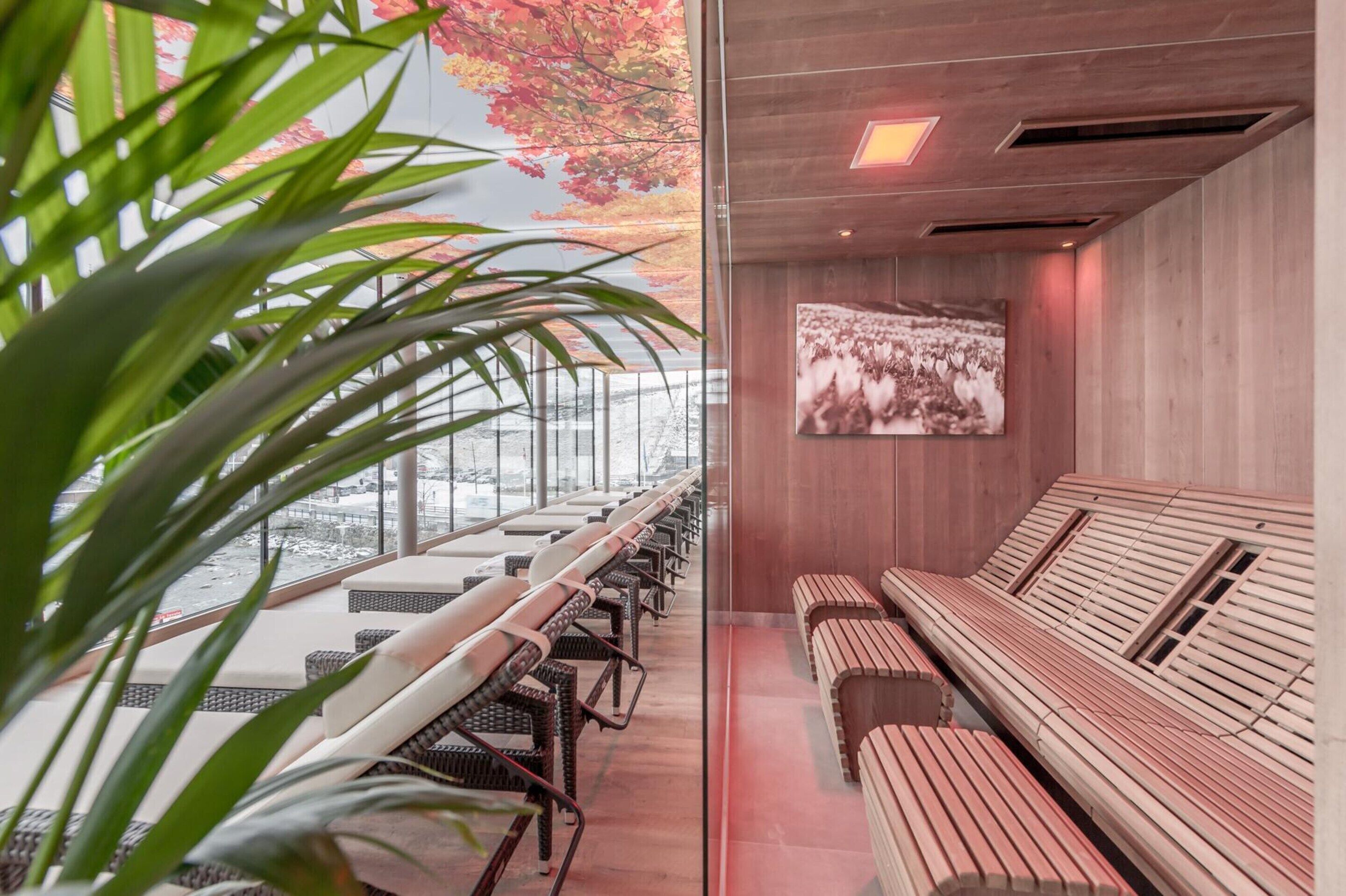 Een moderne lounge met zitplaatsen en een groot scherm aan de muur.