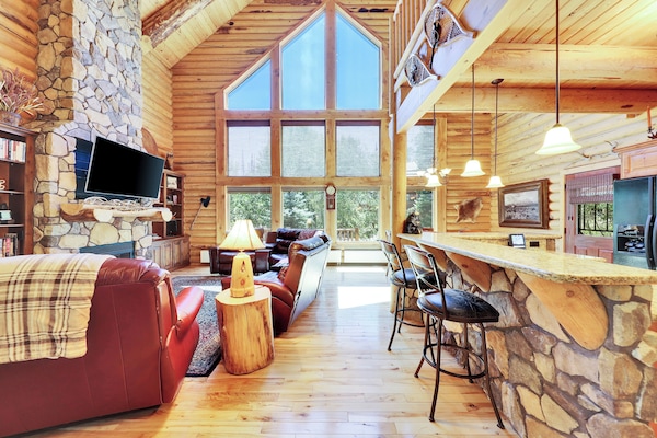 View of Main Living Area, with Expansive Floor to Ceiling Windows and Stone Kitchen Island