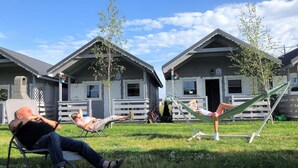 Une rangée de cabanes dotées d’espaces de détente en plein air et de hamacs.