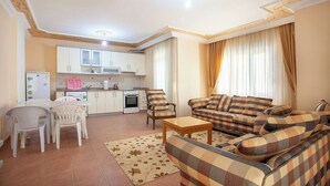 A compact living space with a kitchen, dining area, and a sofa set. - Sevgi Tatil Sitesi (Alanya)