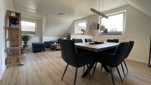 Ein geräumiger Lofts mit Essbereich, Schlafplatz in der Erhöhung und einer Küche.