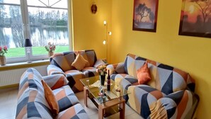 Ein Wohnzimmer mit einer Sofagarnitur, einem Couchtisch und einem Bild an der Wand.