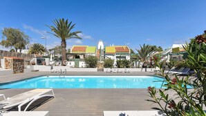 A swimming pool with lounge chairs and a wooden deck. - Central Apartment With Spectacular Terrace-formerly TUI Ferienhaus (San Bartolomé de Tirajana)