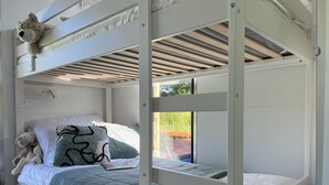 A bunk bed room with a white headboard, a teddy bear, and a magazine on the lower bunk. - Houseboat in Lazy by Lake Jamno and Sea (gmina Sianów)