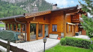 A wooden chalet with a balcony, large windows, and a view of a mountain. - Holiday Home, Krimml (Krimml)