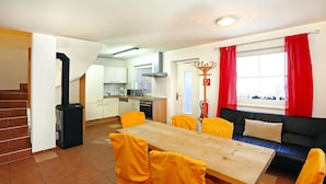 A compact living space with a dining area, a sofa, and a kitchen.