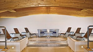 A spa area with wooden ceiling, seating, and a central table with candles. - Appartement Grande Baia Resort, San Teodoro (San Teodoro)