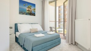 A bedroom with a bed, a nightstand, a window with curtains, and a view of the outside balcony. - Apartment in Pobierowo Near Baltic Beach (Rewal)