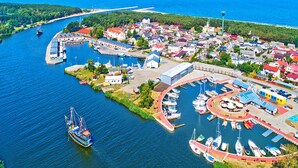 Ein Luftbild einer Küstenstadt mit einem Hafen, Häusern und einer Brücke im Hintergrund.