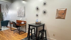 A modern office space with a desk, two chairs, a computer, and decorative wall art.