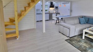 A modern interior with a staircase, a dining area, and a kitchen. - Chalet in Grzybowo Near the Beach (Kołobrzeg)