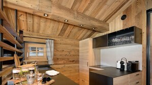 Una cocina moderna con paneles de madera, encimera negra y una estantería empotrada para vinos.
