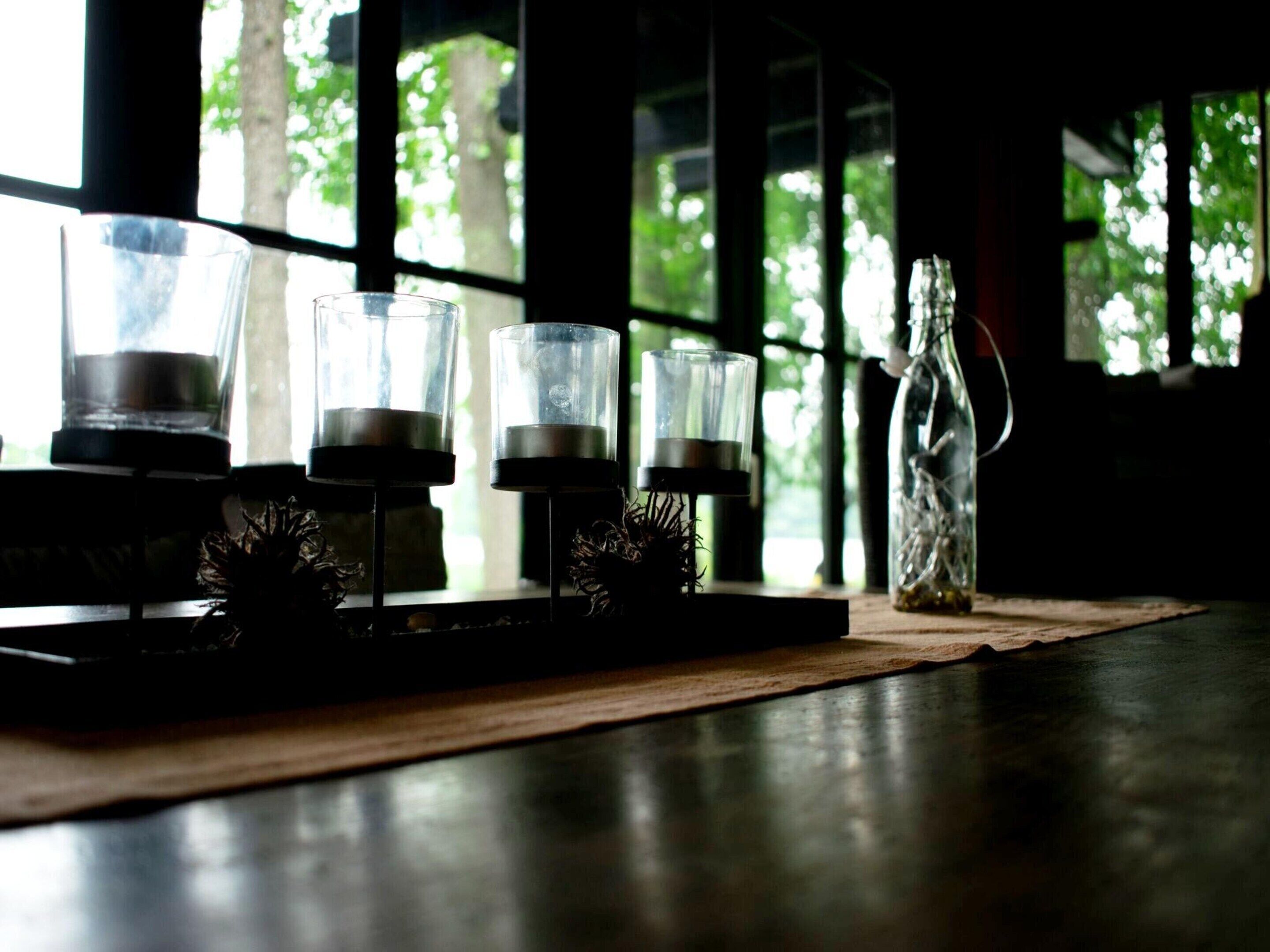Une table avec trois chandeliers et une bouteille en verre.