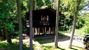 Un rustico chalet con facciata in legno, immerso nel verde.