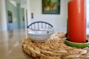 A woven placemat on a wooden table with a candle holder and a bowl. - Reetgedecktes Ferienhaus in Nieblum auf Foehr (Nieblum)