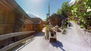 A wooden building with a sloped roof, a wooden fence, and a stone wall with flowers. - Chalet in Wildkogel Near Ski Slopes (Neukirchen am Grossvenediger)