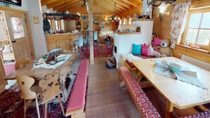 A cozy cabin interior with wooden beams, a bar area, and a dining space with benches and a table. - Chalet in Wildkogel Near Ski Slopes (Neukirchen am Grossvenediger)