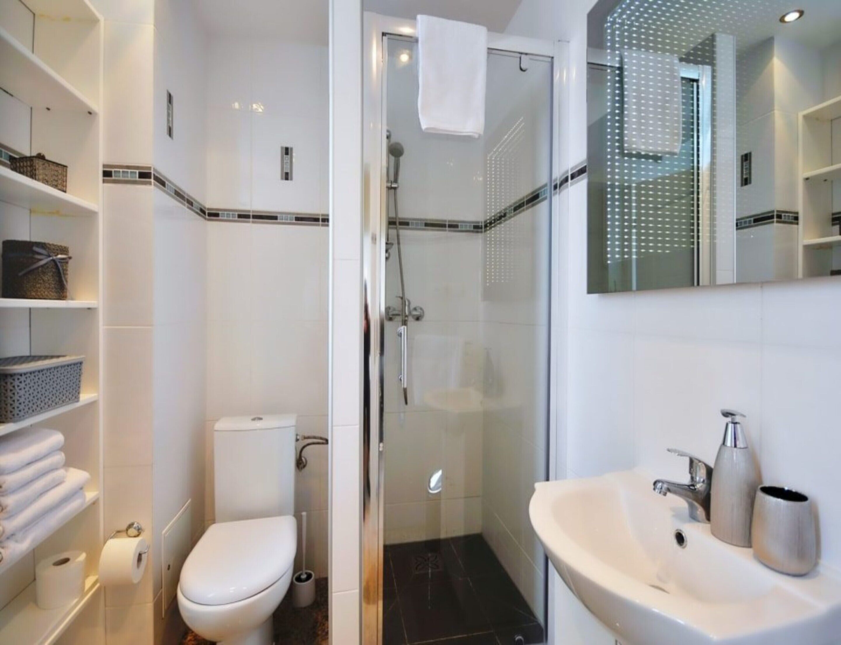 A modern bathroom with a toilet, shower, and sink.