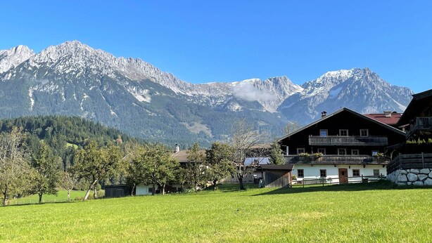 Un paysage de montagne avec des sommets enneigés et un ciel bleu dégagé.