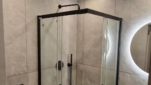 A modern bathroom with a glass-enclosed shower, a round mirror, and a white sink. - Apartment, Beautiful View, Szklarska Poreba (Szklarska Poreba)