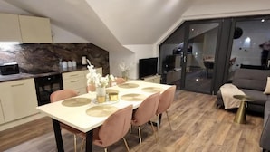 A modern dining area with a table set for four, surrounded by chairs with gold legs. - Apartment, Beautiful View, Szklarska Poreba (Szklarska Poreba)