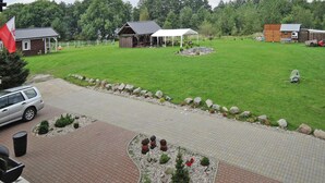 Ein Wohngebiet mit gepflasterter Auffahrt, einem kleinen Garten mit Dekosteinen und einer weißen, zeltartigen Struktur im Hintergrund.