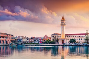 A waterfront view with a prominent tower and colorful buildings along the shore.