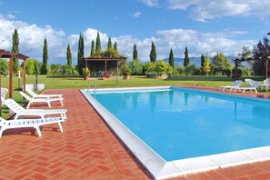 Relax by the serene pool surrounded by a patio, pergola, and gazebo.