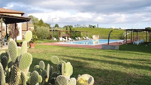 A pool area with lounge chairs and a cactus garden. - Agriturismo Poggio al Sole, Vinci (Vinci)