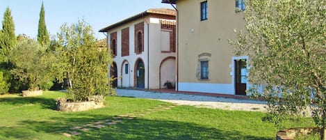 A two-story building with a garden in front.