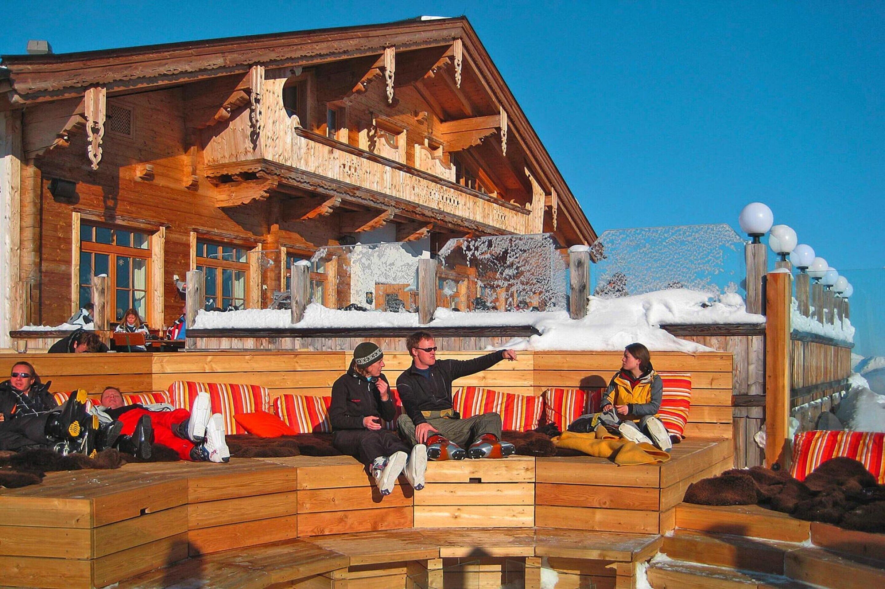 Un chalet de madera con balcón y techo cubierto de nieve.