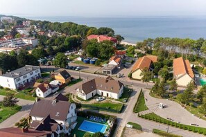 A residential area with houses, a swimming pool, and a view of the sea. - Holiday Apartment, Pool, Close to Beach, Rewal (Rewal)