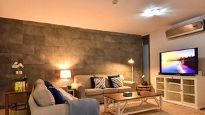 A modern living room with a sofa, coffee table, and TV. - Holiday Home With Pool on Golf Resort, Maspalomas (San Bartolomé de Tirajana)
